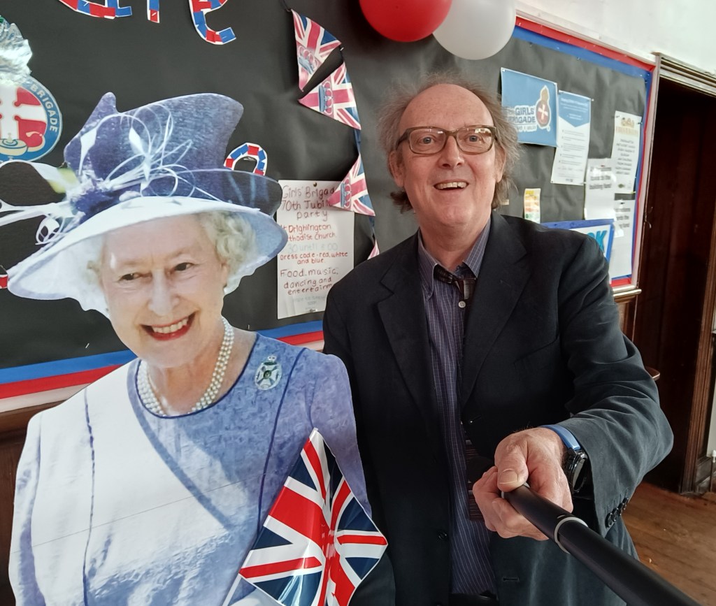 Cut out of the Queen next tutor with a selfie stick both smiling