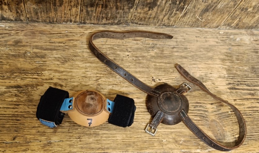 Left: modern bell muffler plastic cup with leather pad with Velcro straps attached. Right: old bell muffler leather cup with leather straps and buckles.