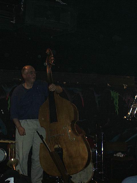 Simon H Fell perspiring after tough performance standing with his Double Bass.