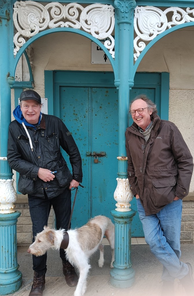 Ron left with his dog, Vic left both leaning on seaside the pillars of the seaside pavilion.