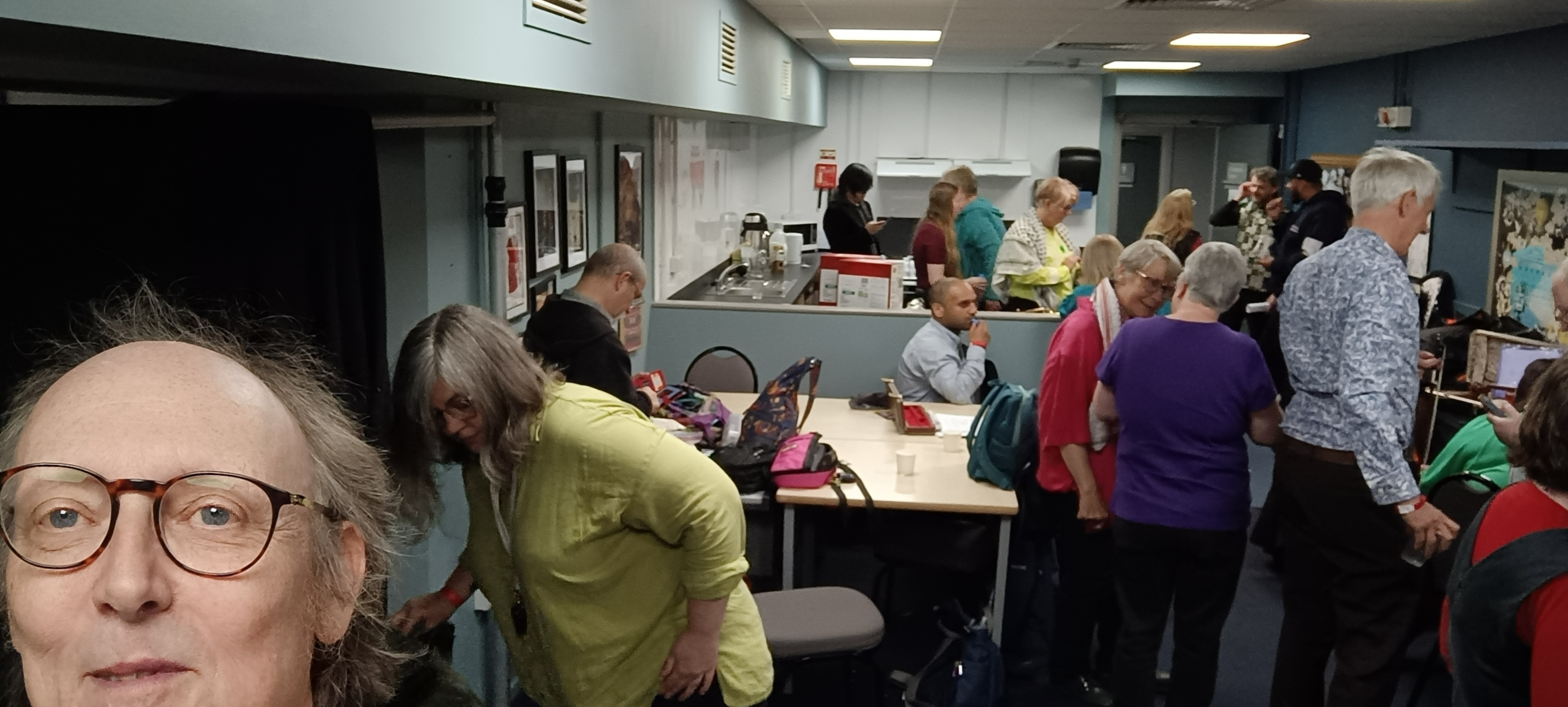 Many musicians crowded together in the narrow dressing room