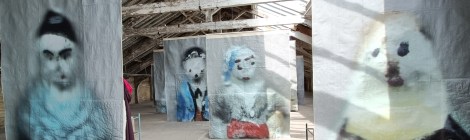 View burred figures printed on suspended artwork in the exhibition hall