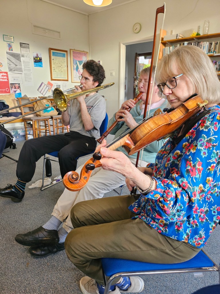 Left to Right: Trombonist, Treble Recorder player, and Violinist, all playing their instruments.